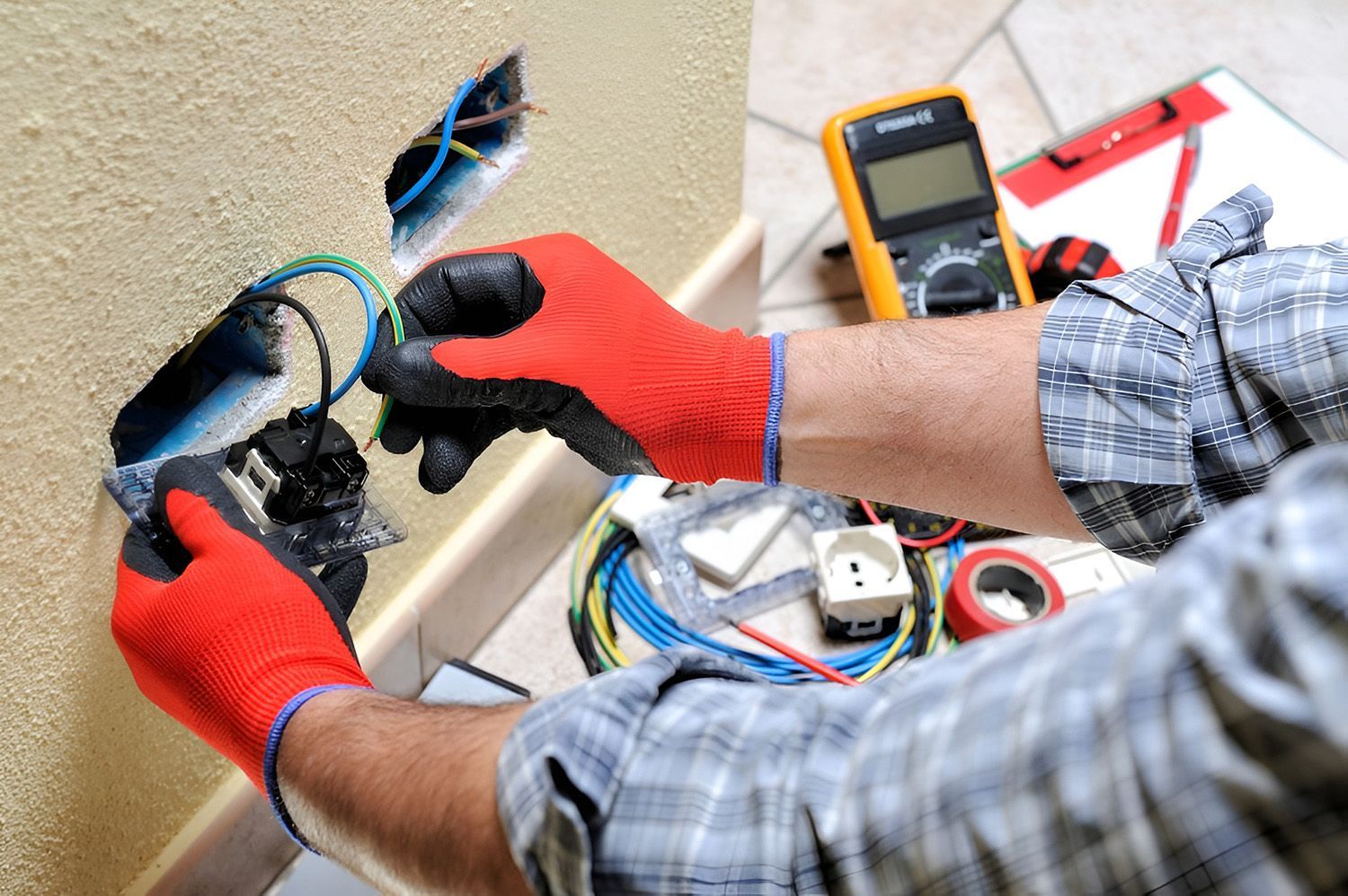 Electrician in Red Gloves Wiring an Electrical Outlet