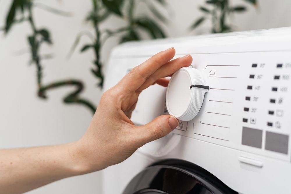 Woman Moving the Timer on Washing Machine — Hennig Electrical Services in Nambour, QLD