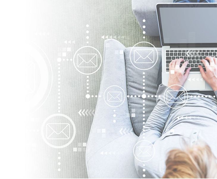 A woman is sitting on a couch using a laptop computer.