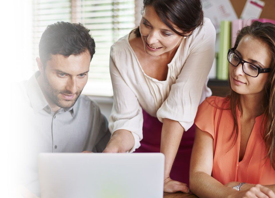 A group of people are looking at a laptop computer.