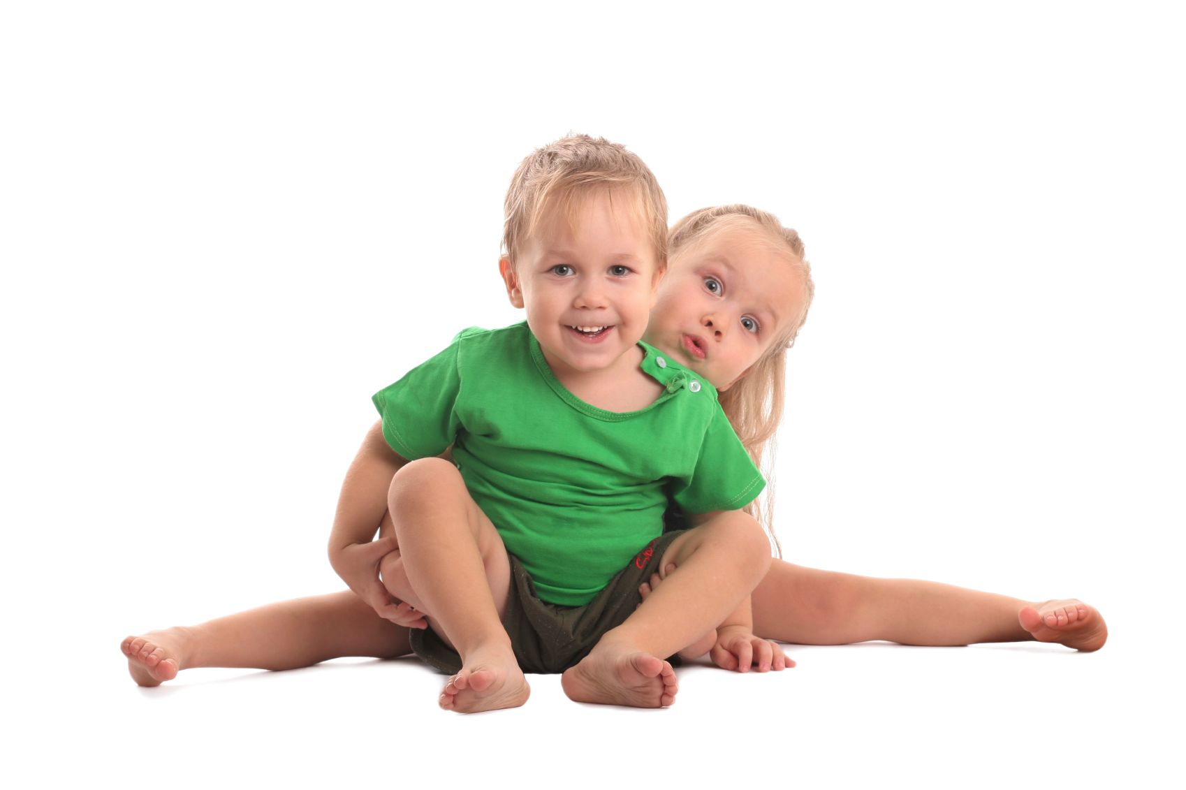 A boy and a girl are sitting next to each other on the floor.