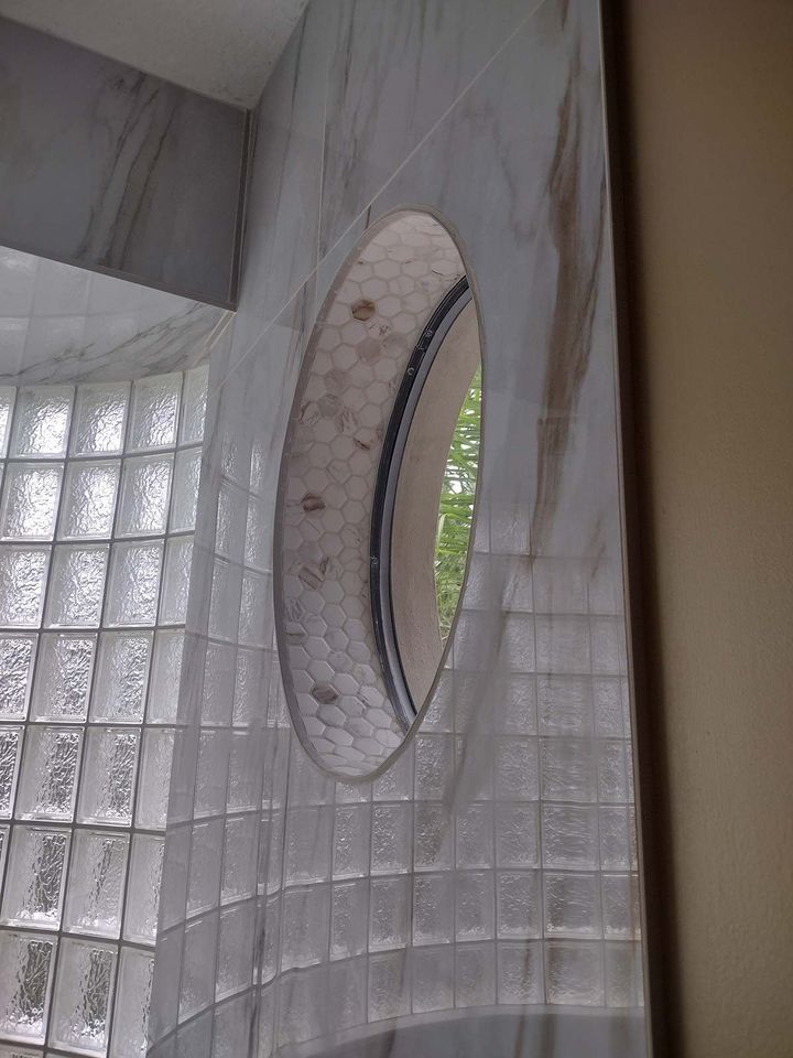 a bathroom with a round window in the wall