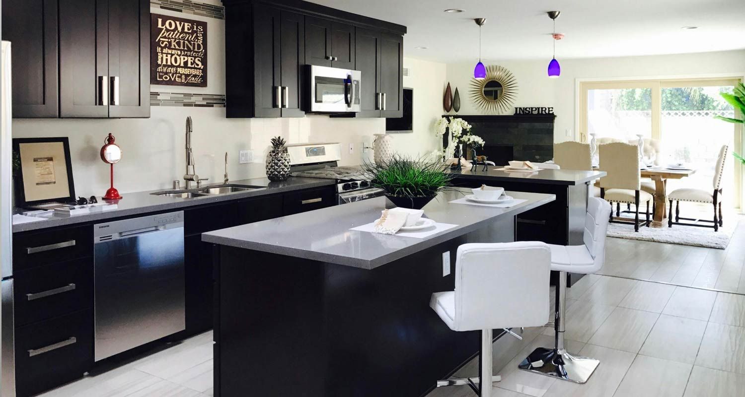 a kitchen with black cabinets and stainless steel appliances