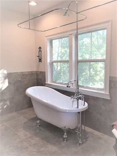 a bathroom with a bathtub and two windows