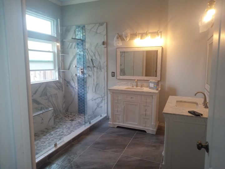 a bathroom with a sink , mirror and walk in shower