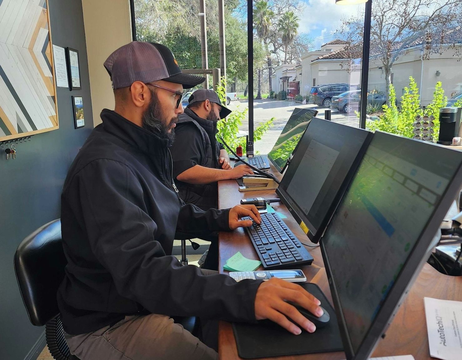 Two men wearing hats and jackets work at computers | Ojai Valley Imports