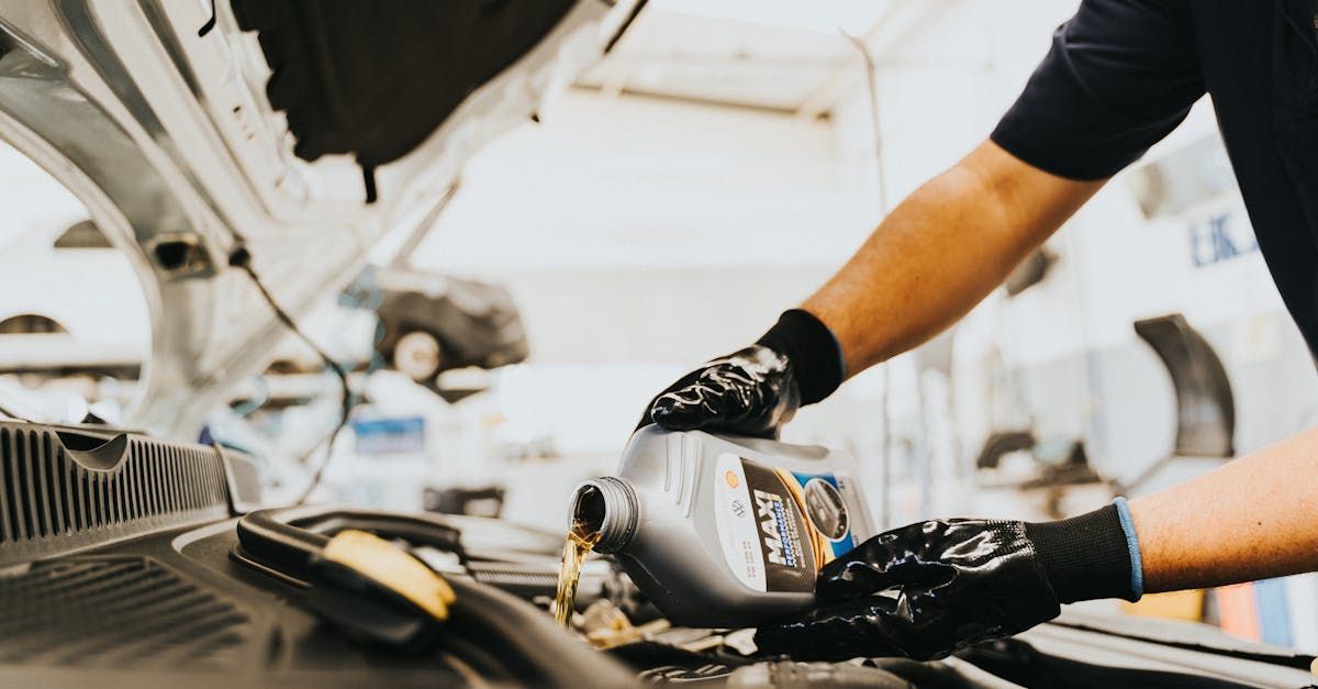 Mechanic adding oil in car