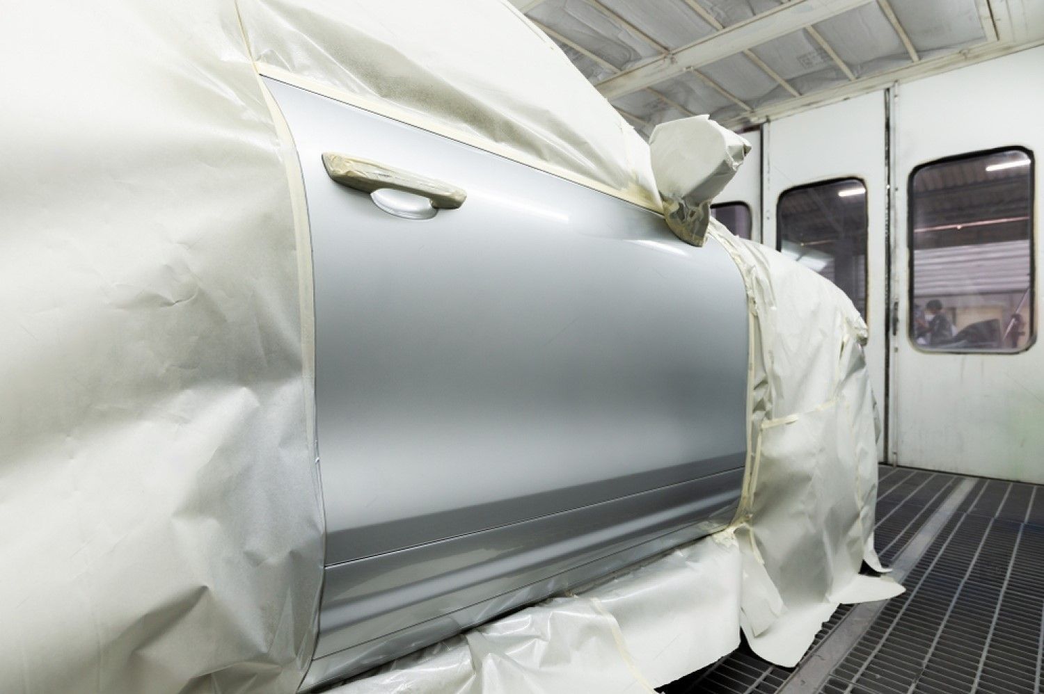 A car is being painted in a paint booth.