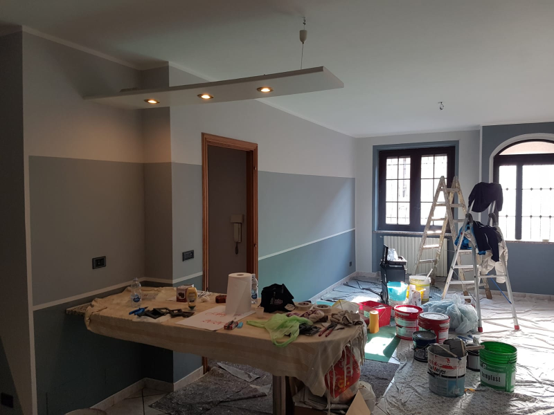 Si sta dipingendo una stanza con un tavolo e secchi di vernice.