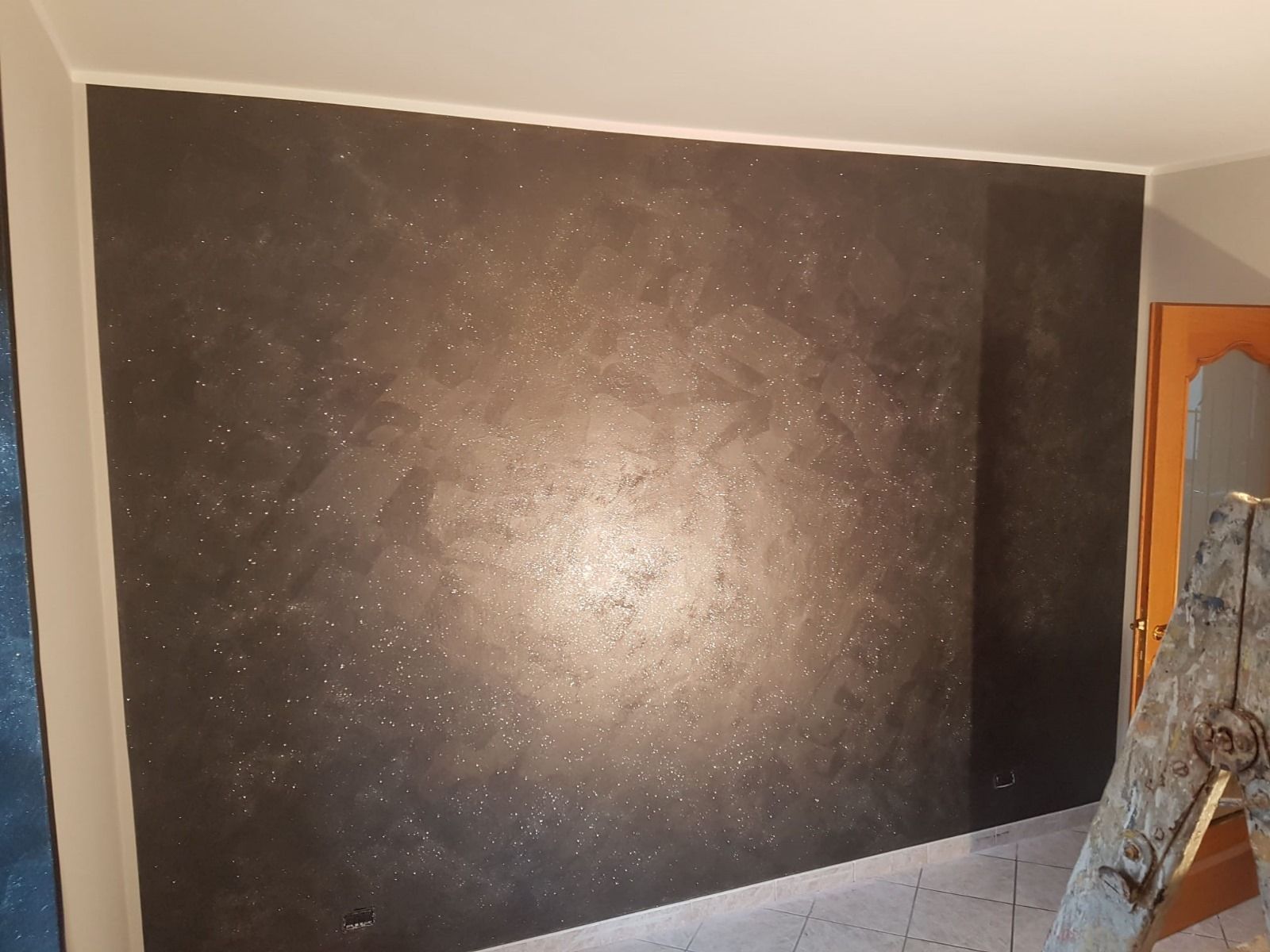 Una stanza con un muro nero e una scala di fronte