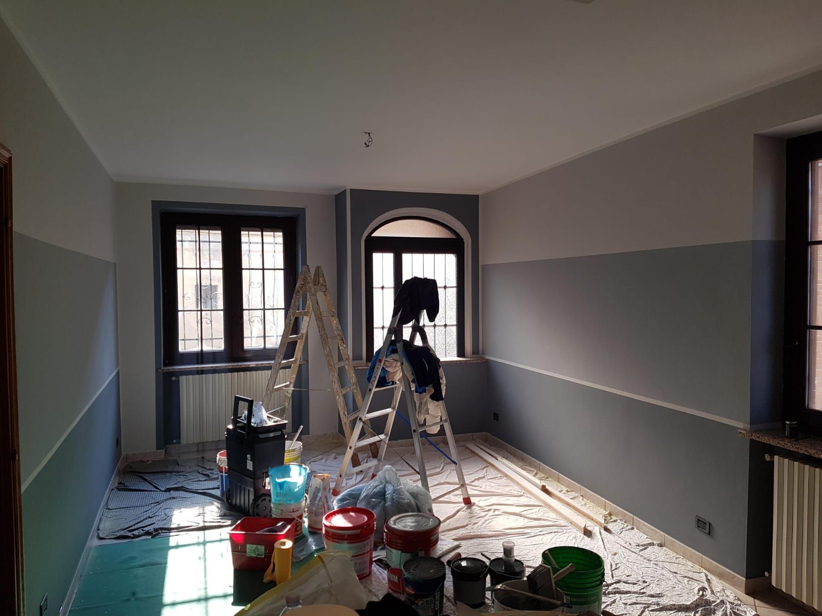 Una stanza viene dipinta con una scala e secchi di vernice.