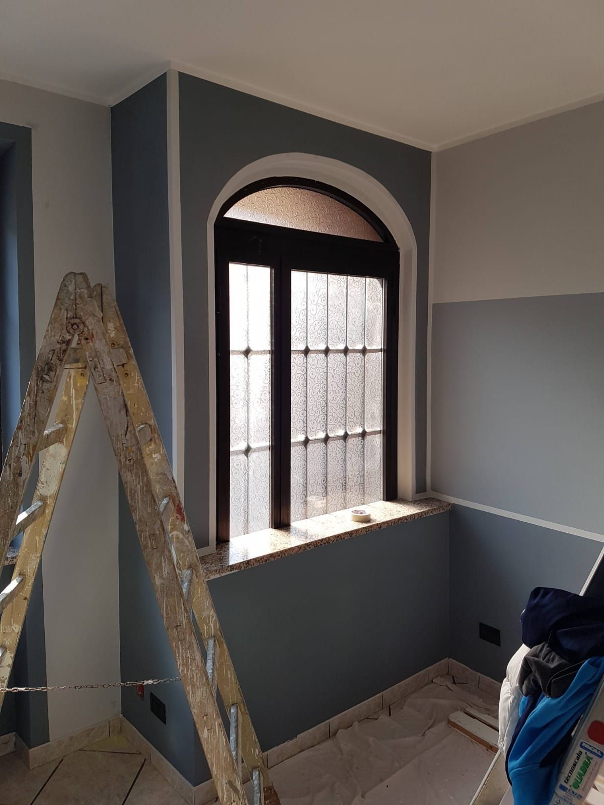 Una stanza con una finestra e una scala al suo interno