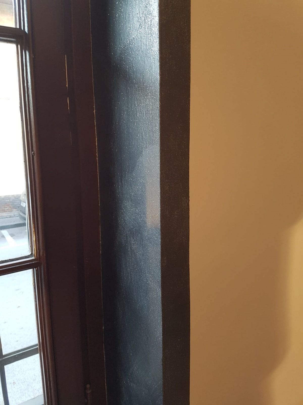 Un primo piano di una finestra in una stanza con una parete bianca.