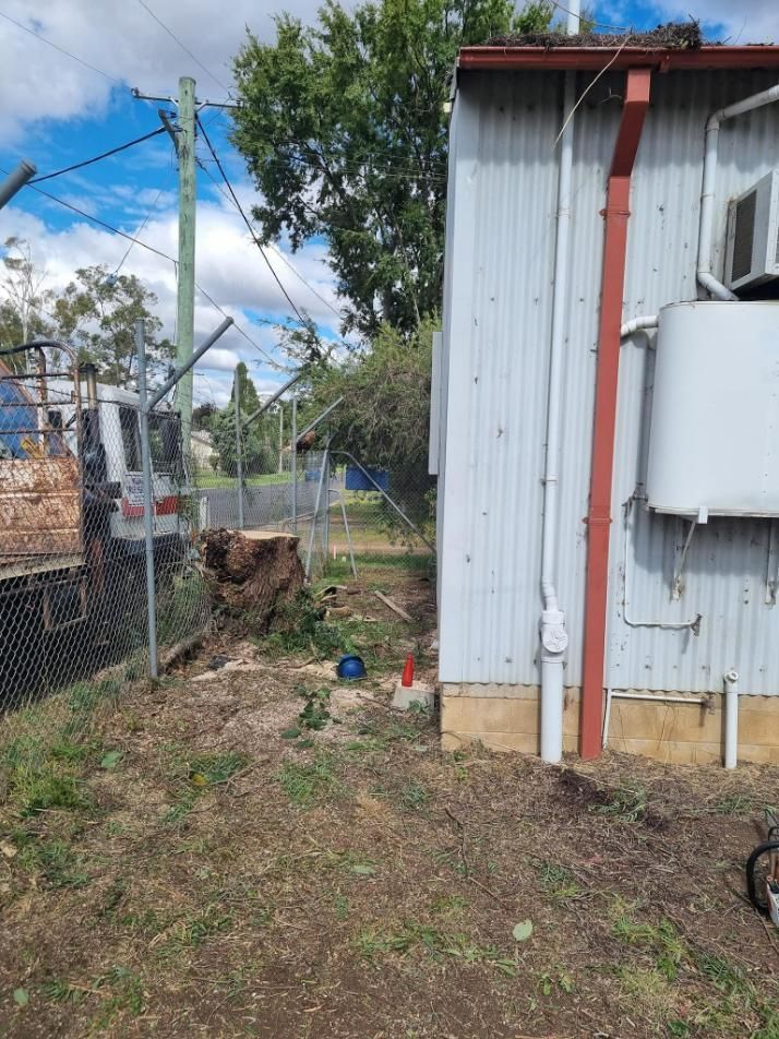 A White Building With a Red Trim is Surrounded by a Fence — Mudgee Tree Services in Eurunderee, NSW