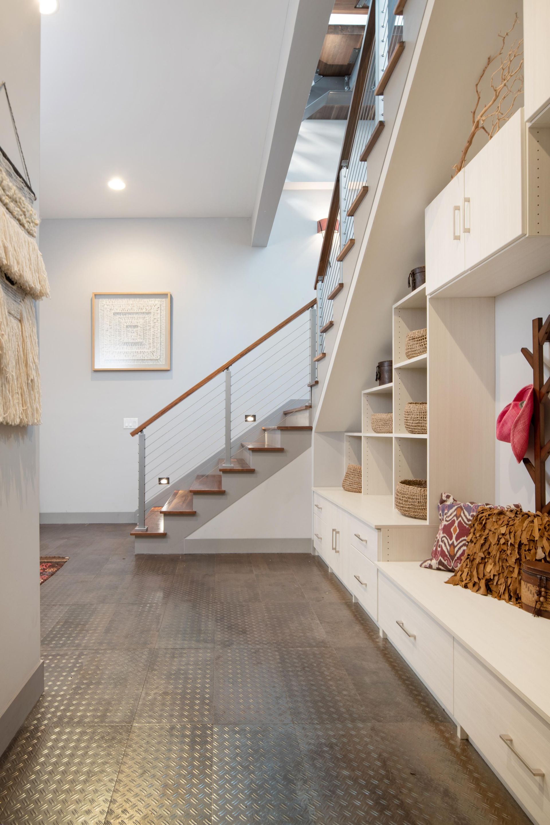 A hallway with stairs leading up to the second floor