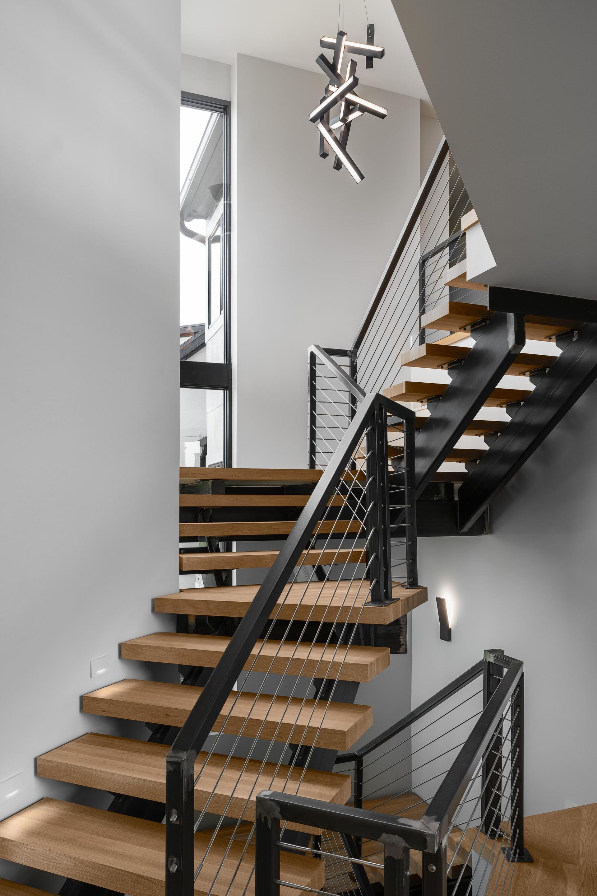 A modern staircase with wooden steps and a metal railing.