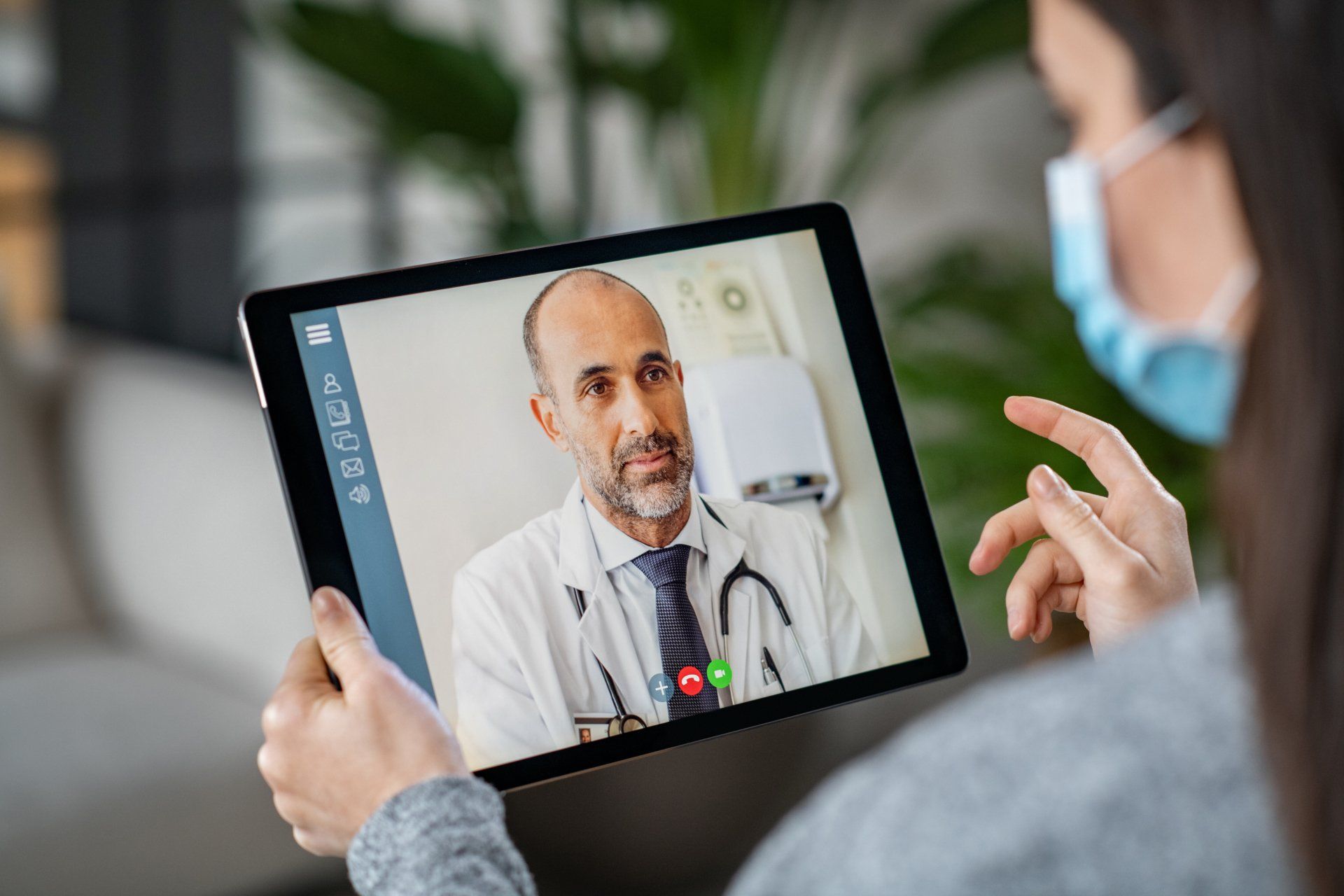 Doctor on tablet having tele health meeting with patient.