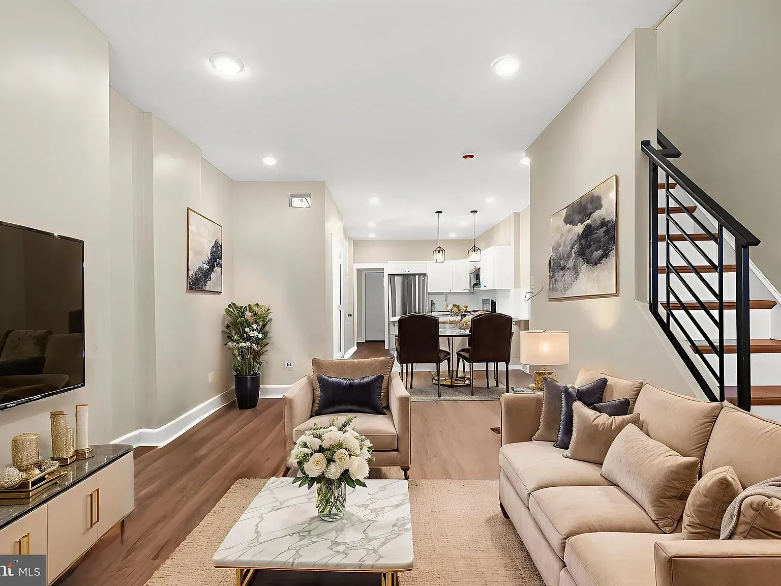 Gray house with a front porch, garage, and landscaping.