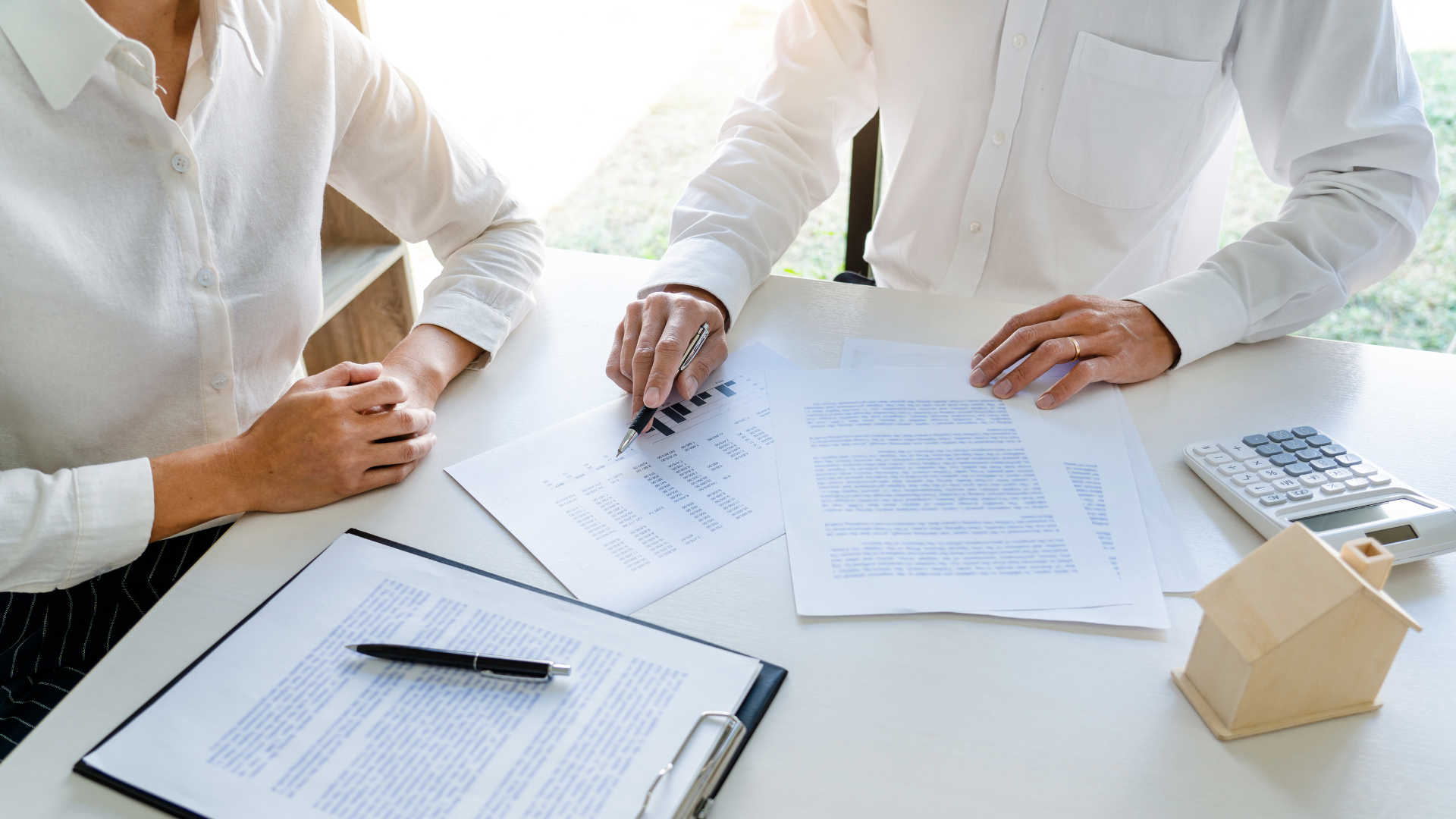 Real estate agent points out features of a home to a couple.