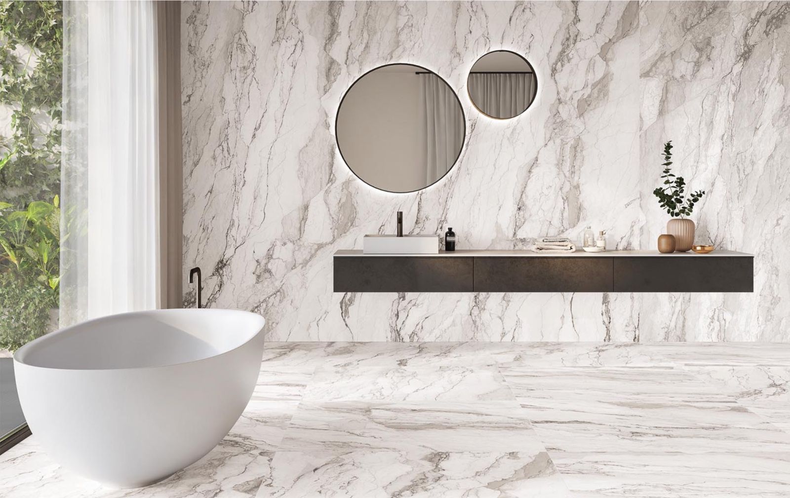 Bagno moderno con pareti e pavimento in marmo bianco, vasca da bagno, mobile lavabo sospeso e specchi rotondi.