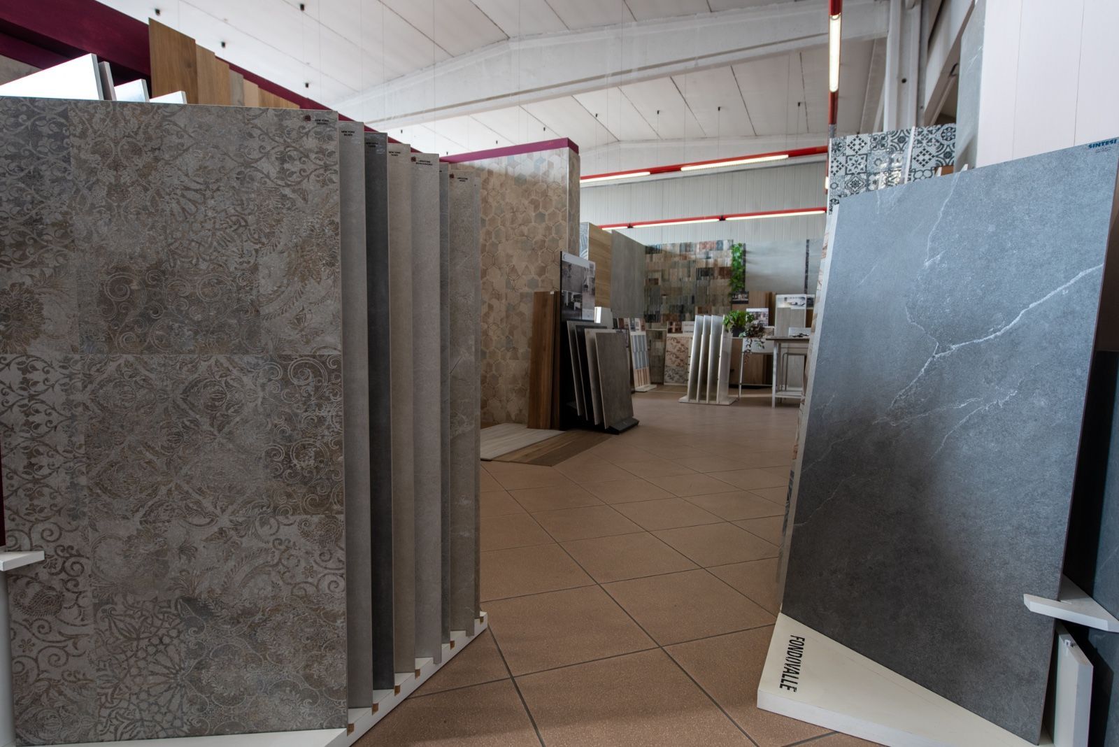 Showroom di piastrelle con esposizione di varie piastrelle effetto pietra, ripresa dell'interno.