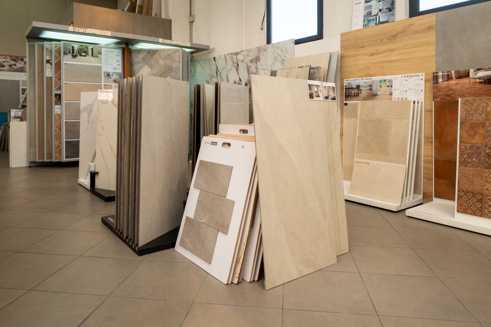 Showroom di piastrelle con vari campioni di piastrelle esposti su espositori.