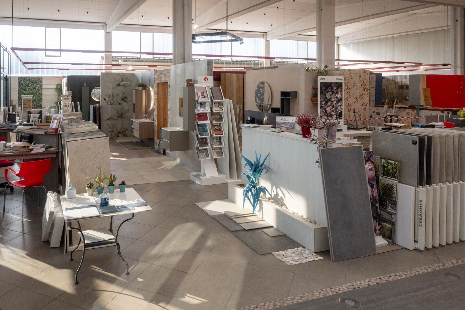 Interno di uno showroom di piastrelle e design, in cui sono esposti vari campioni di piastrelle ed elementi di design.