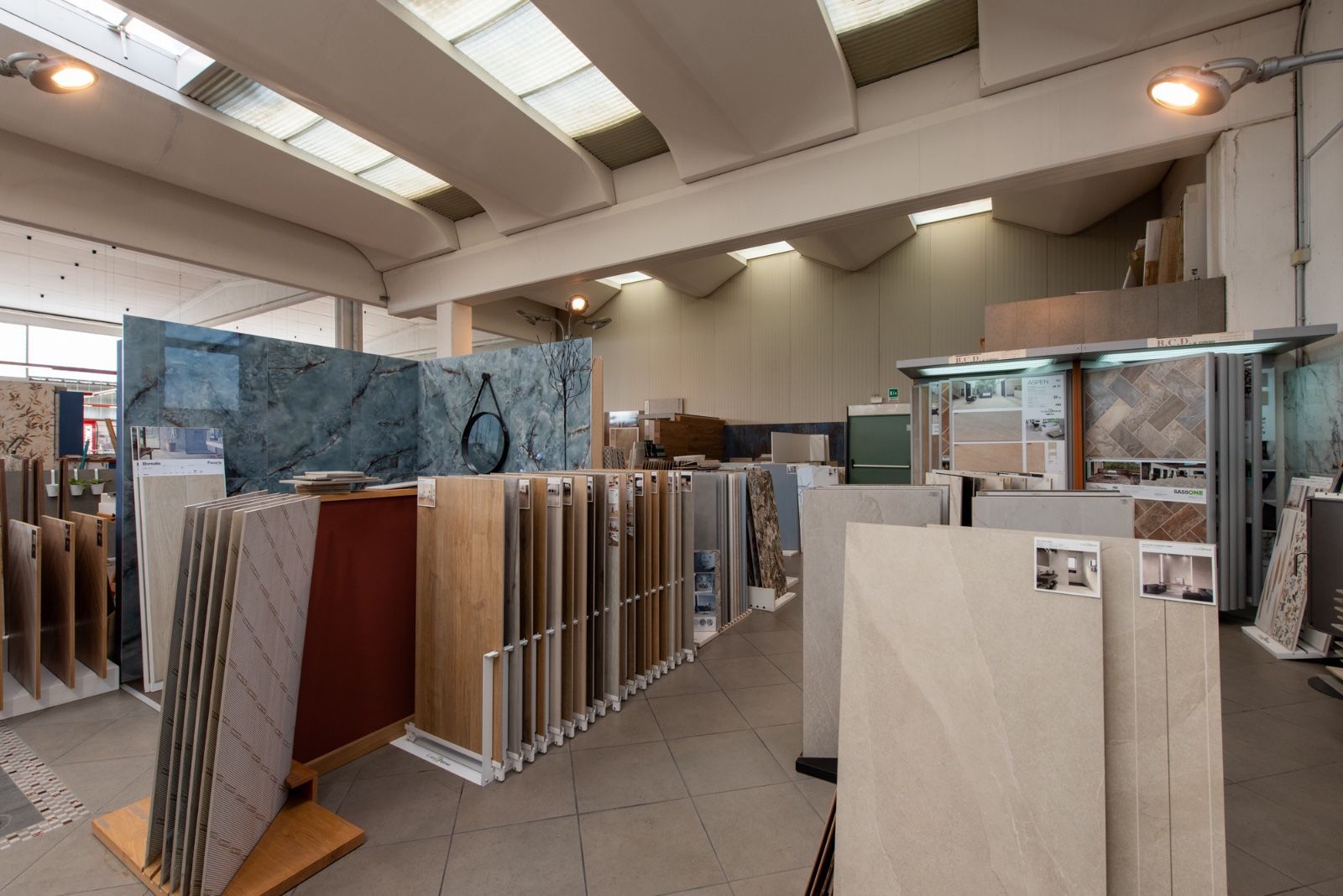 Showroom di piastrelle con varie esposizioni di piastrelle e illuminazione intensa.