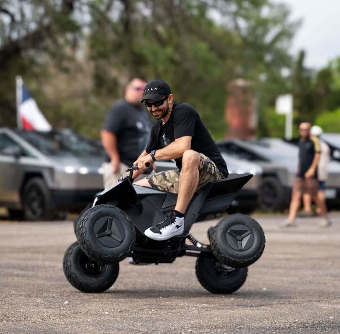 A man is riding a small atv in a parking lot