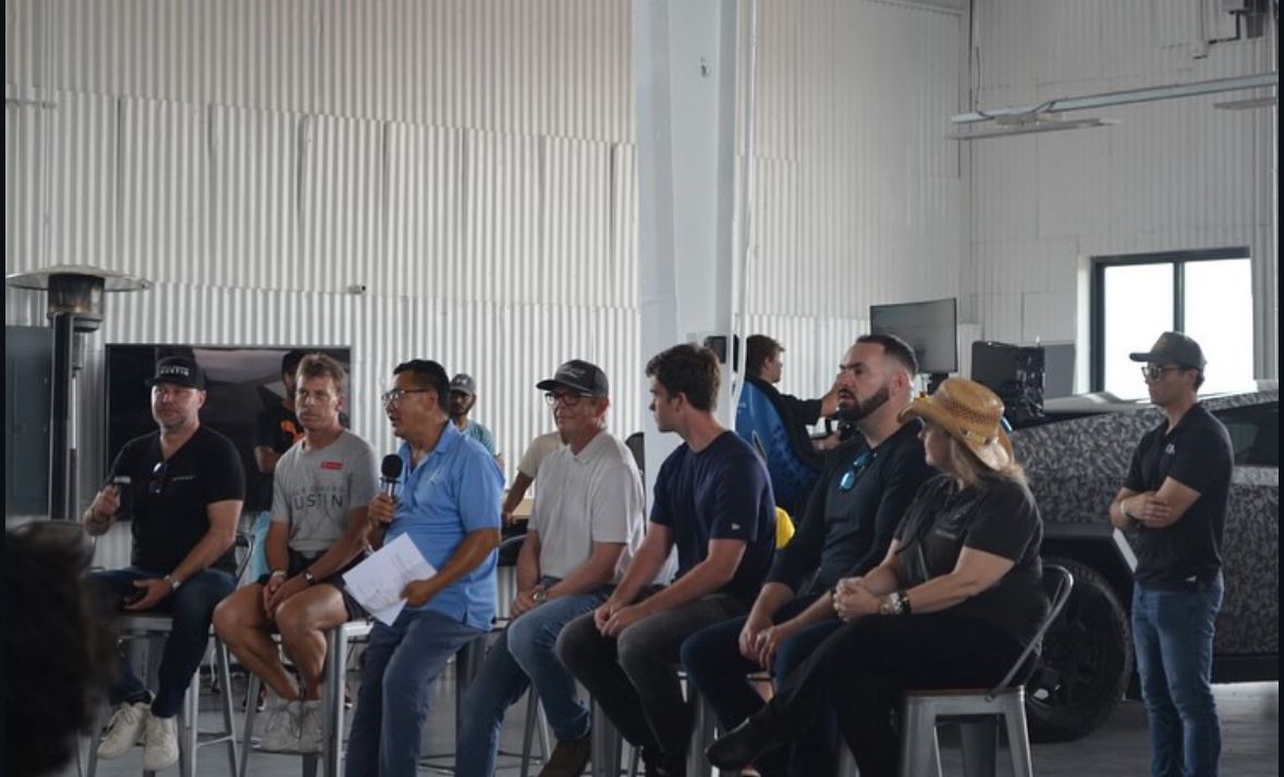 A group of people are sitting on stools in a room.