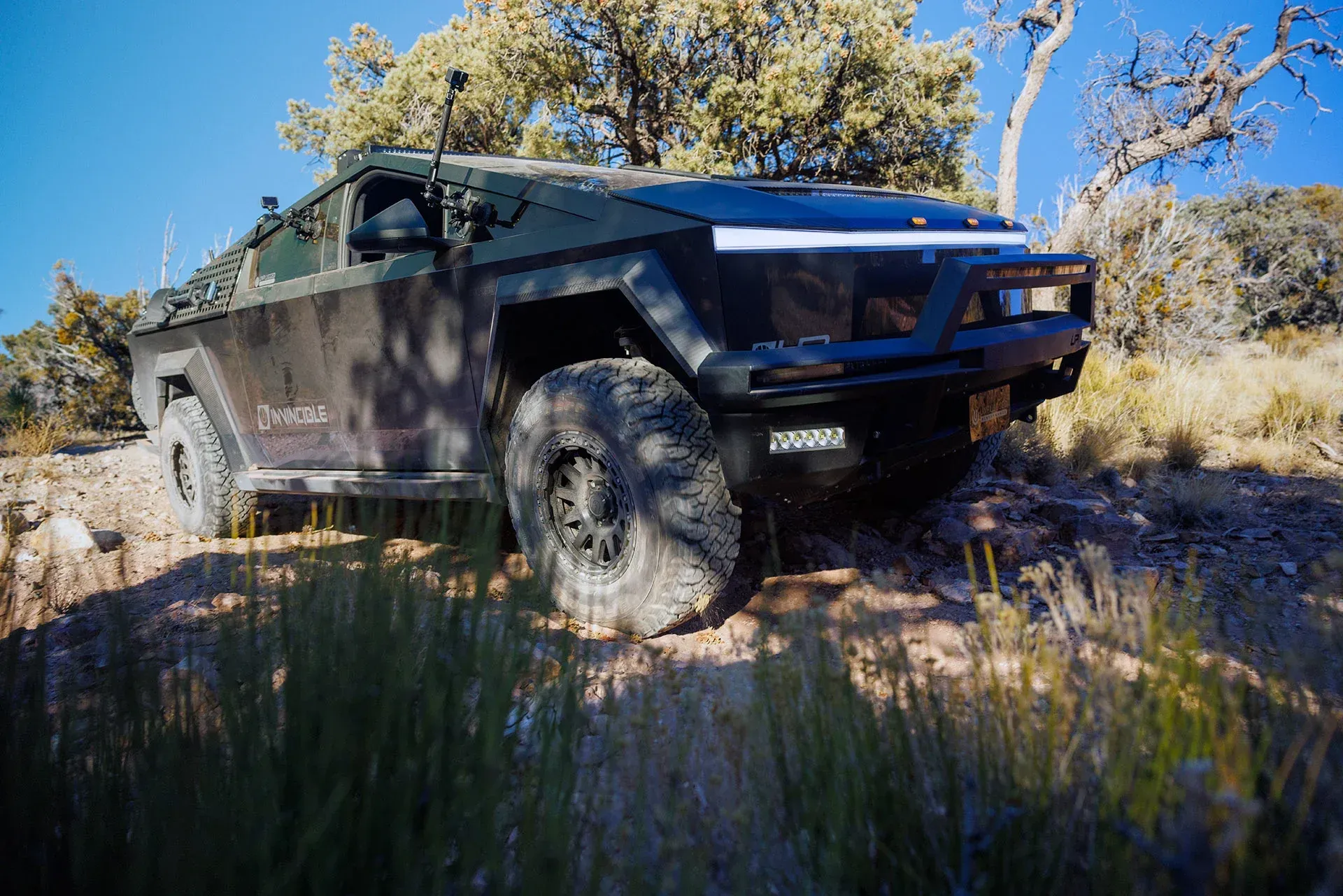 A military vehicle is driving down a dirt road.