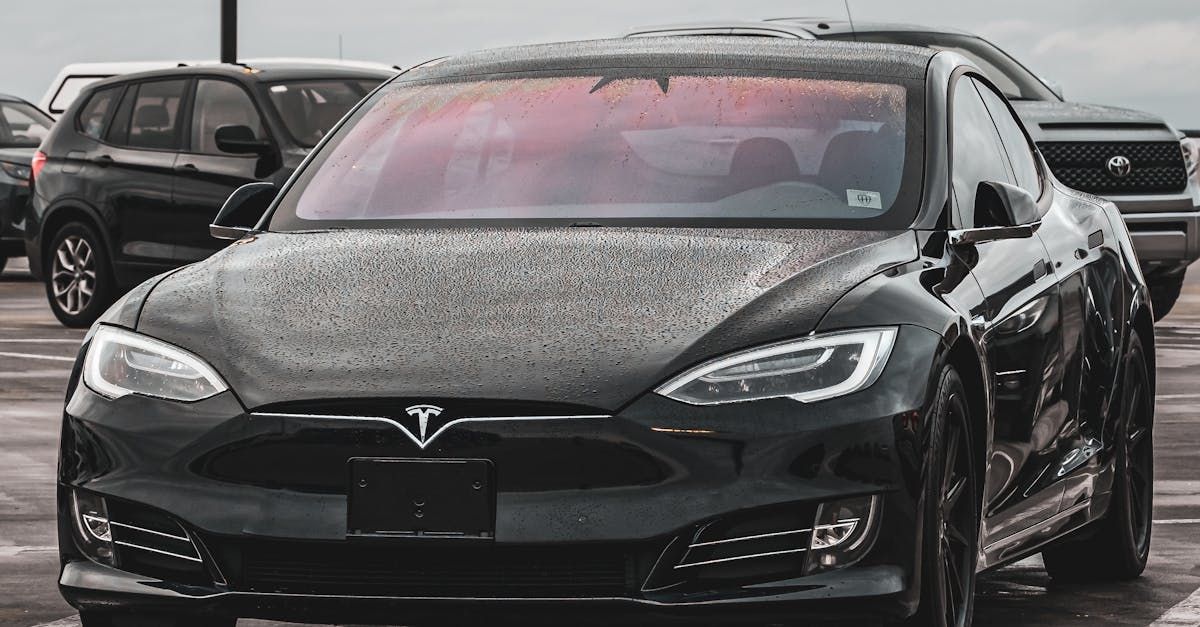 A black tesla model s is parked in a parking lot.