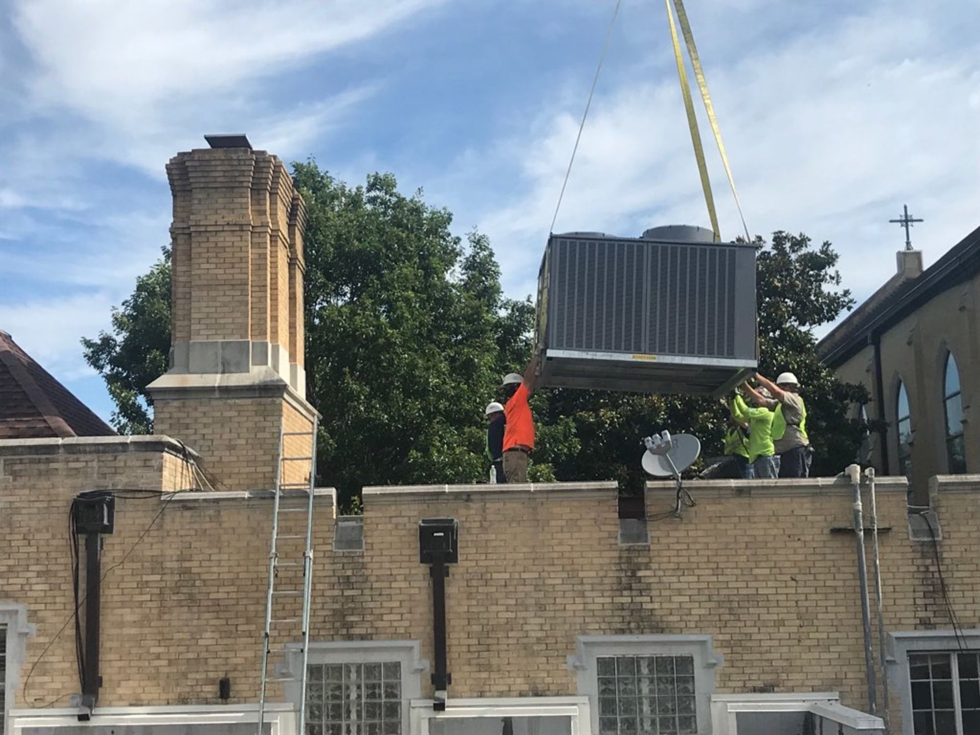 A crane is lifting a large box on top of a building