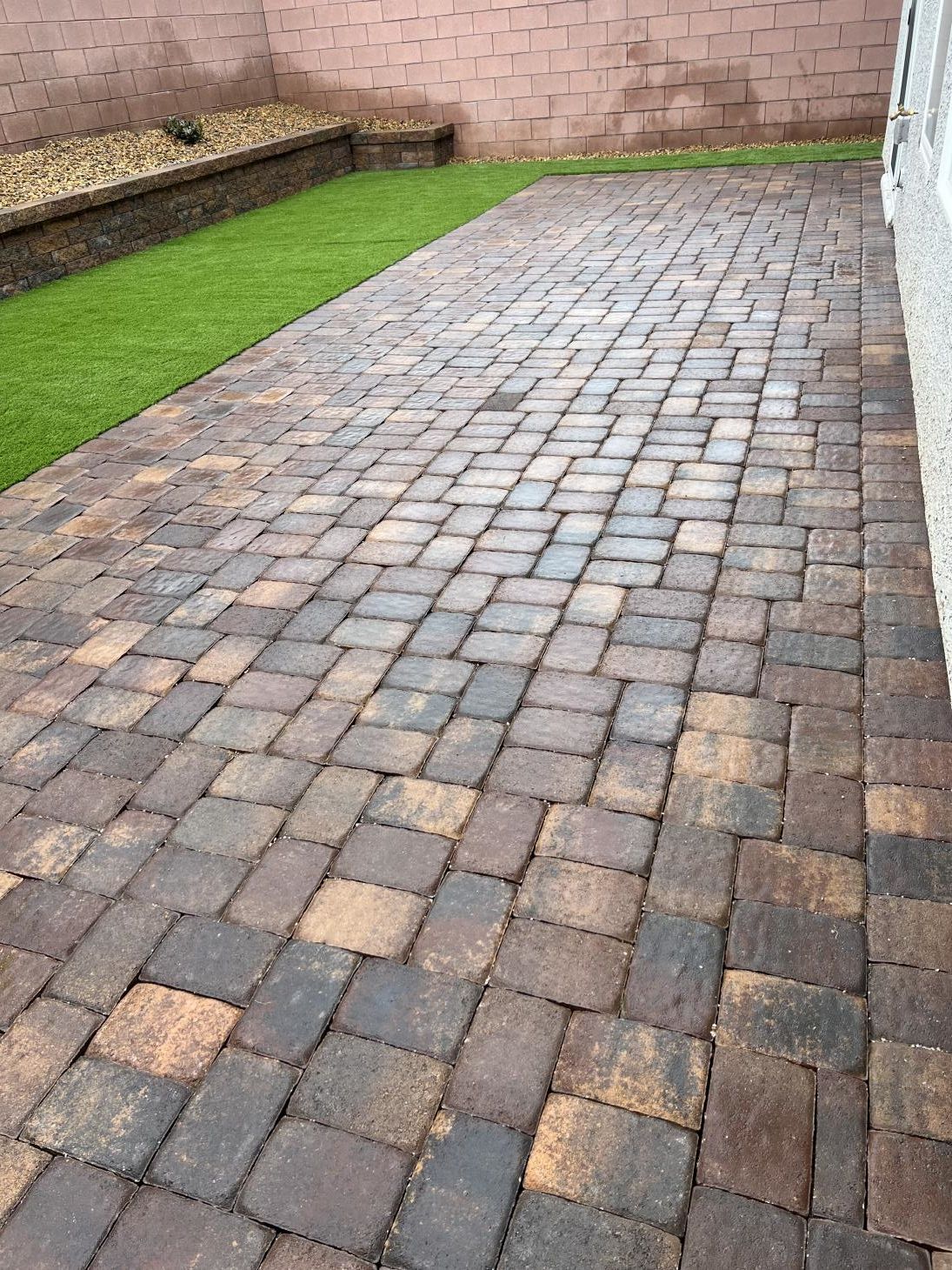 A person is watering plants in a garden with a watering can.
