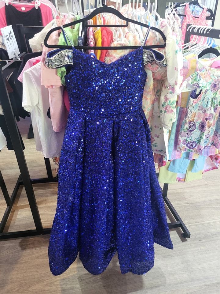 A blue dress is hanging on a rack in a store.
