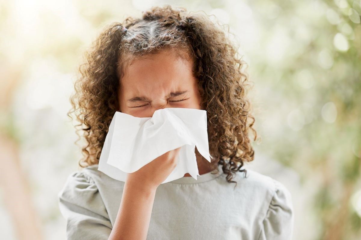 A young girl is blowing her nose due to pollen allergy.