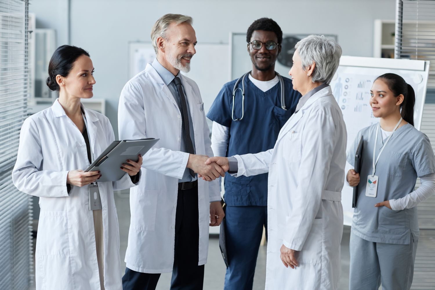 A group of doctors are shaking hands in a hospital.