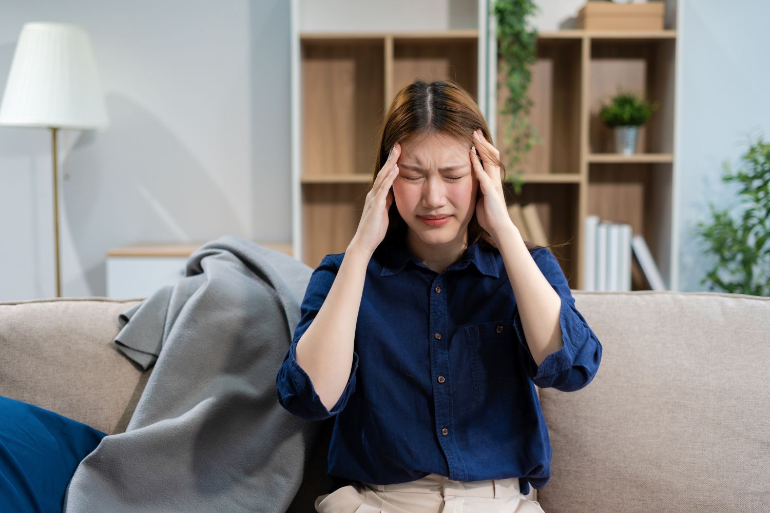woman-having-headache-while-sitting-down