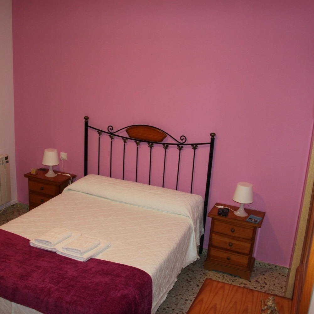 A bedroom with pink walls and a bed