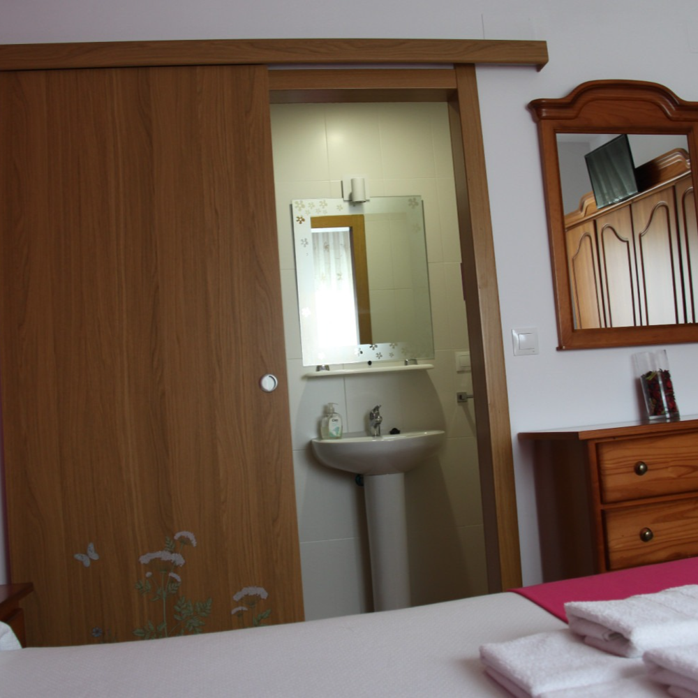 A bedroom with a sliding door leading to a bathroom