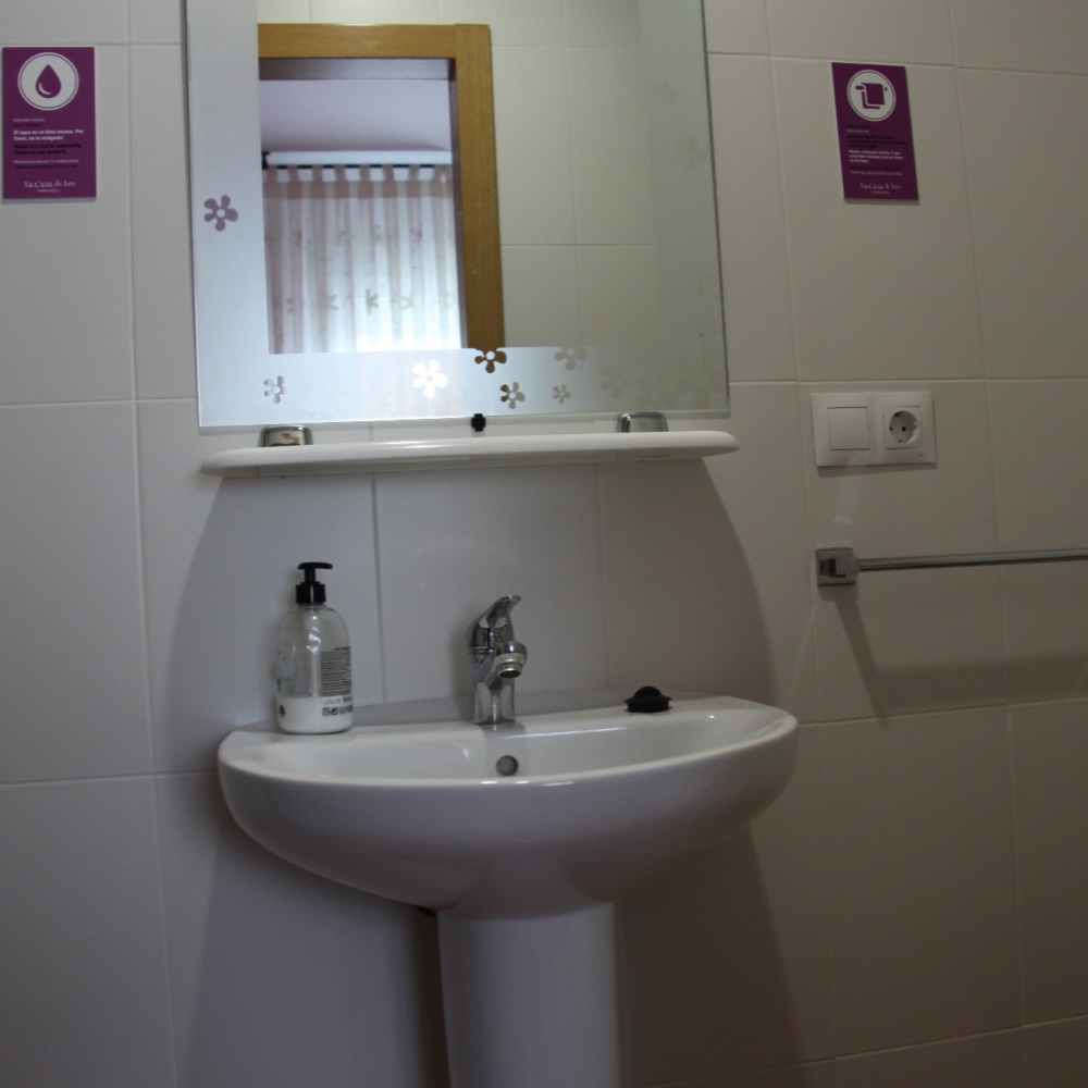 A bathroom with a pedestal sink and a mirror
