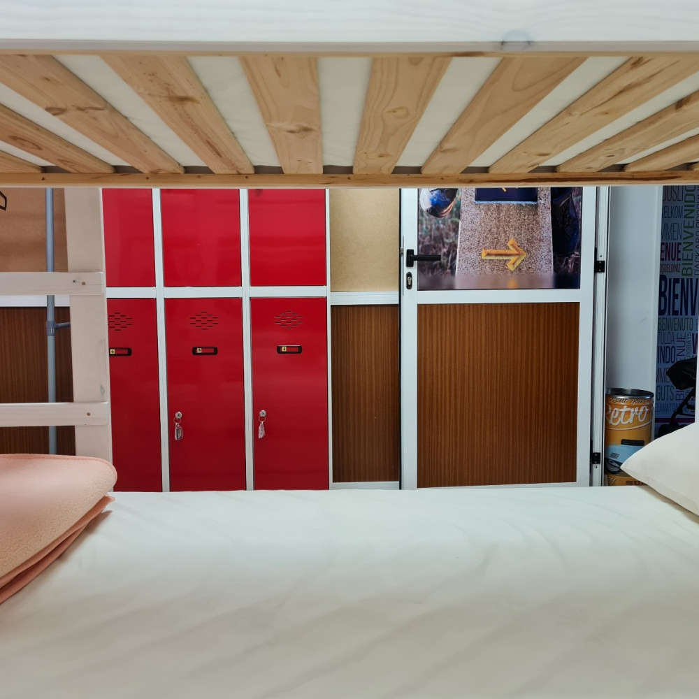 A bunk bed in a room with red lockers