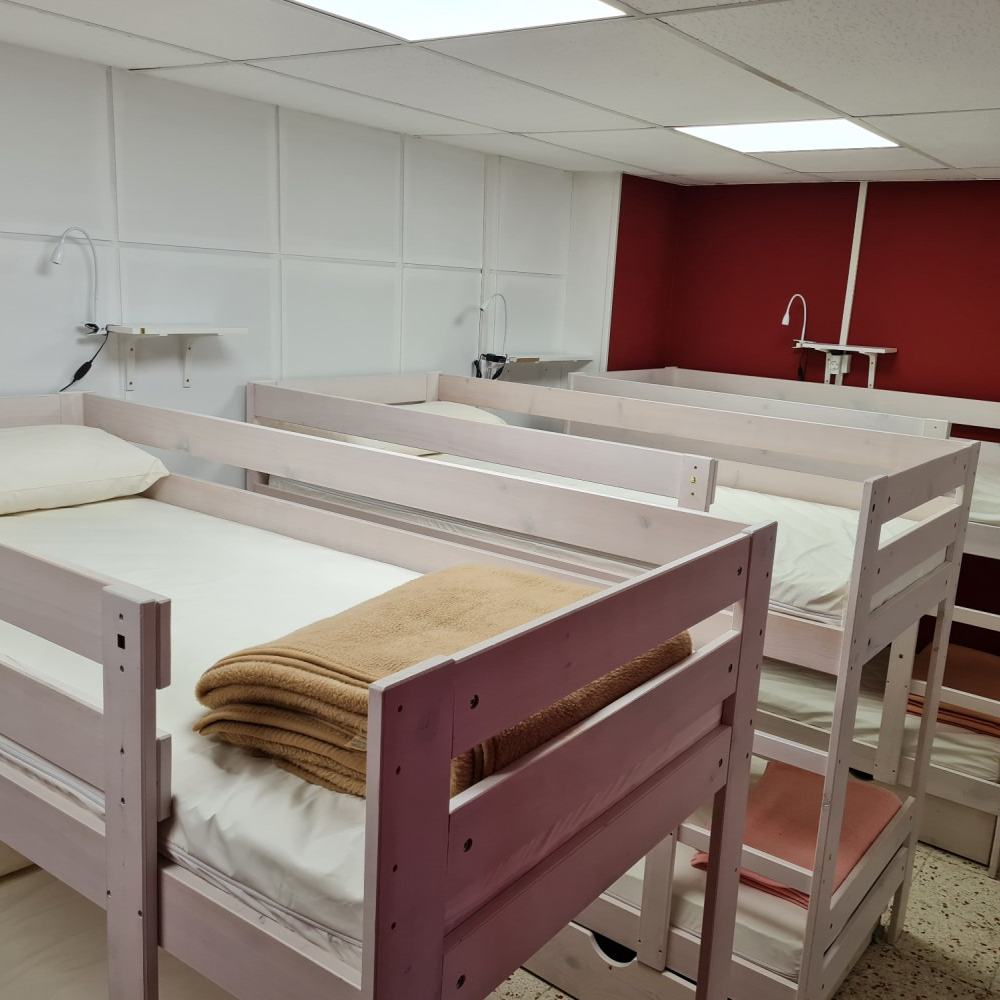 A row of bunk beds with blankets on them