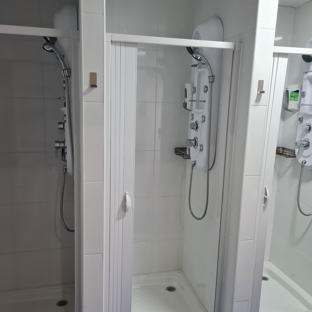 A bathroom with two shower stalls and a mirror
