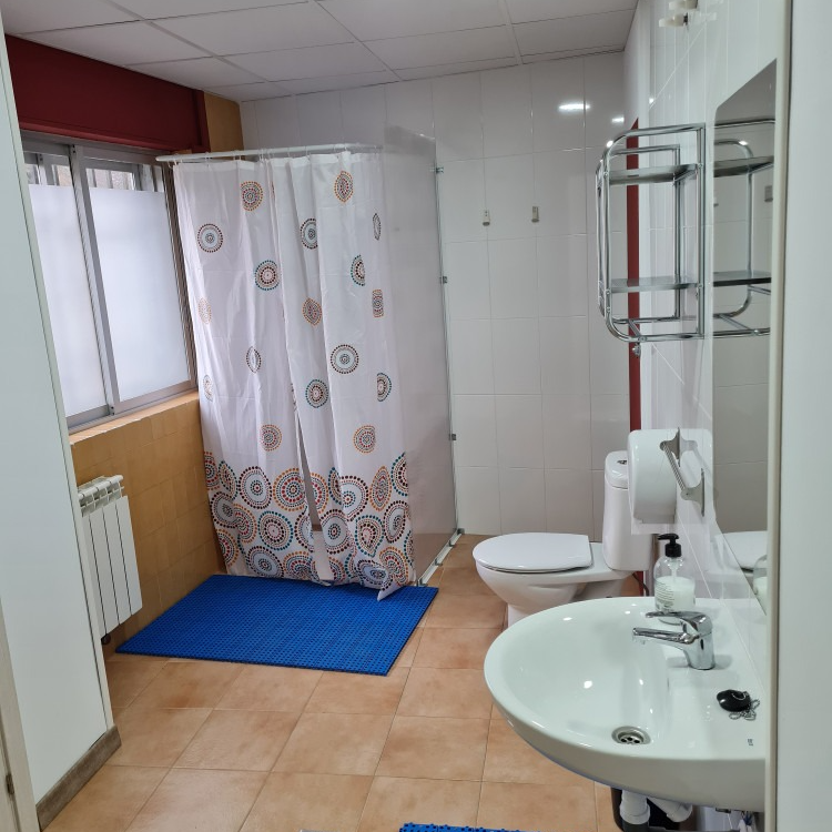 A bathroom with a sink toilet and shower curtain