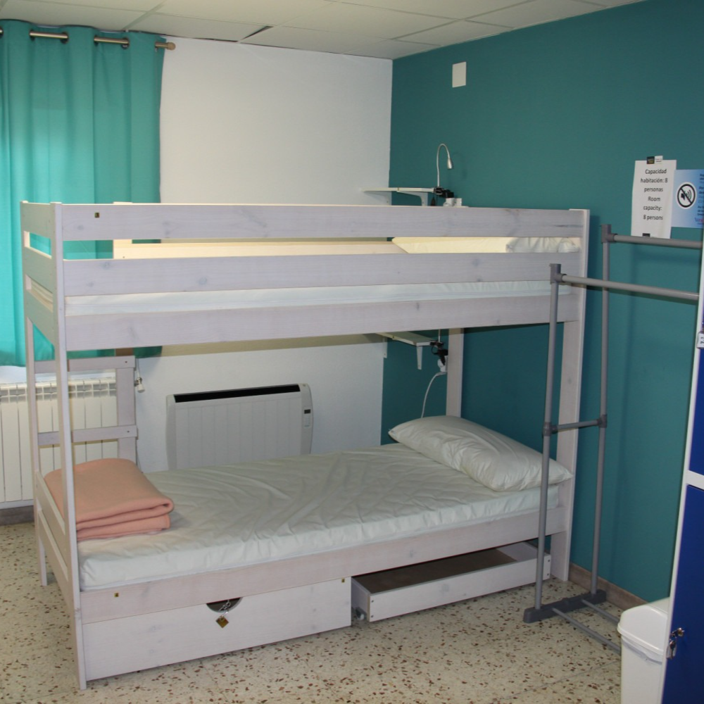 A bunk bed in a room with a blue wall