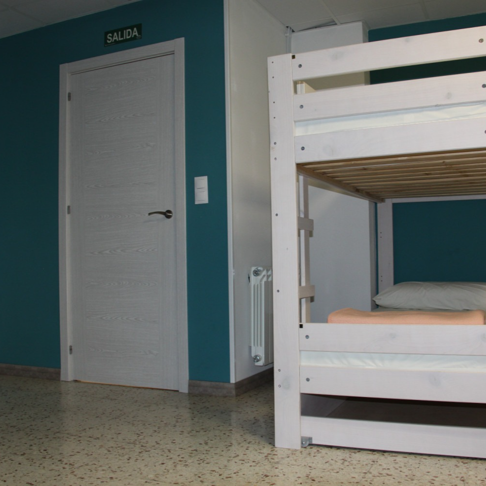 A room with a bunk bed and a sign that says salida