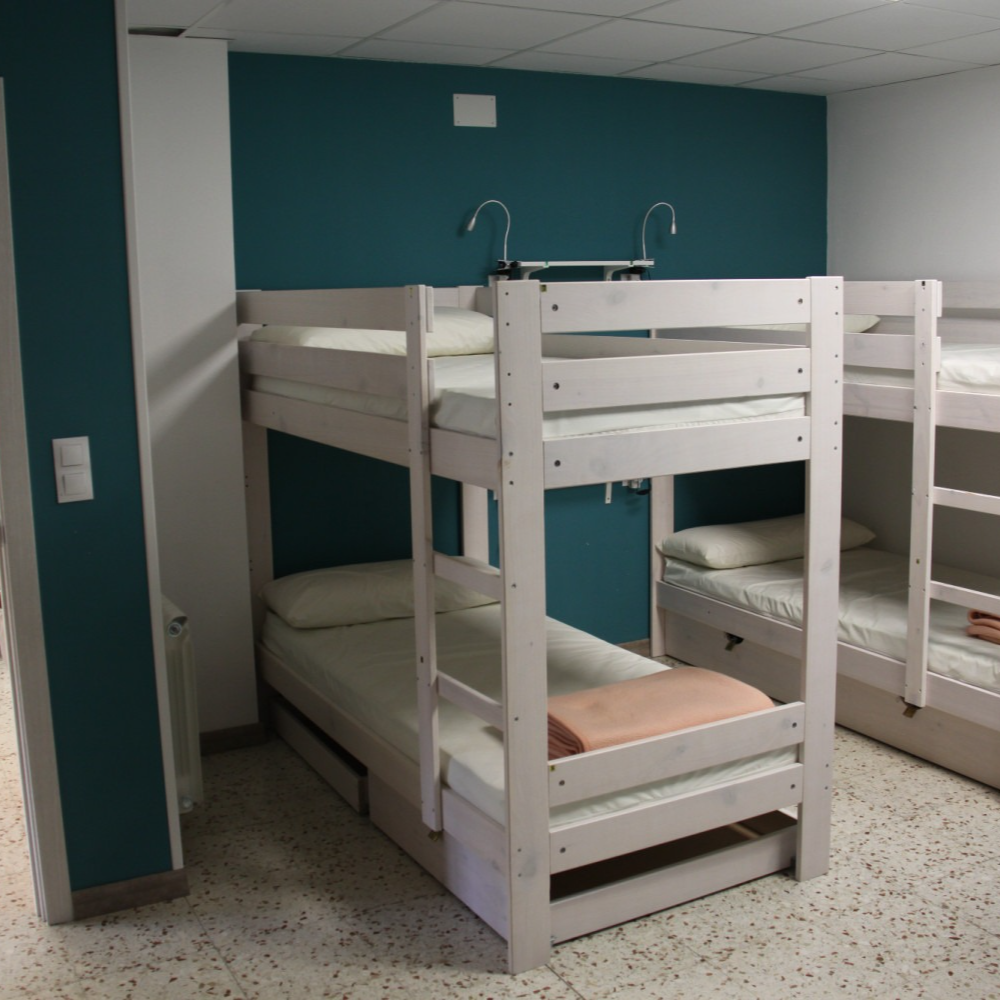 A room with bunk beds and a blue wall