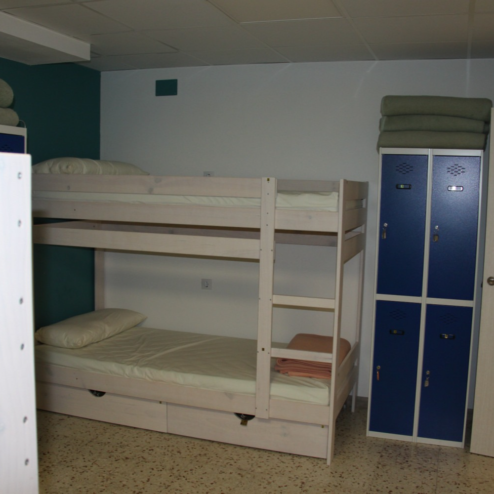 A bunk bed in a room with blue lockers