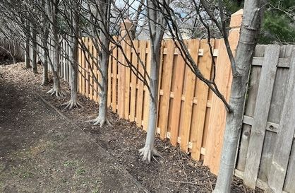 Modern bathroom with gray tiled walls, sink, large mirror, and glass shower.